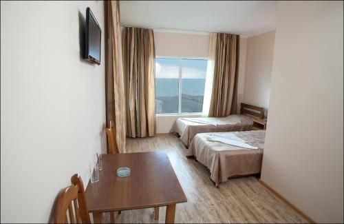 乌雷基Hotel Premium的酒店客房设有两张床、一张桌子和一个窗户。