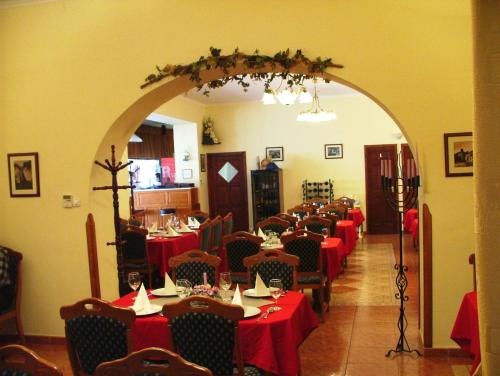 沙罗什保陶克Rákóczi Panzió的一间设有红色桌布的餐桌的用餐室