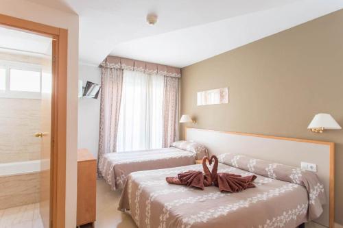塔拉戈纳宇宙塔拉戈纳酒店的酒店客房设有两张床和窗户。