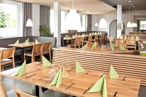腓特烈港沃尔德霍恩酒店的餐厅设有木桌和绿纸椅子