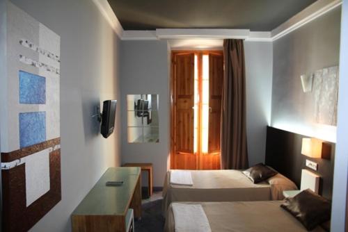 休达鲁伊兹广场旅馆的酒店客房配有床、沙发和桌子。