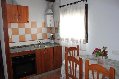 科尼尔-德拉弗龙特拉Apartamento Fatima的厨房配有水槽和桌椅