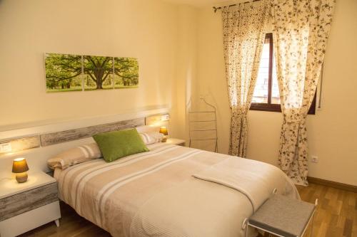 马拉加Jardines del Litoral Momas Homes的一间卧室设有一张大床和一个窗户。