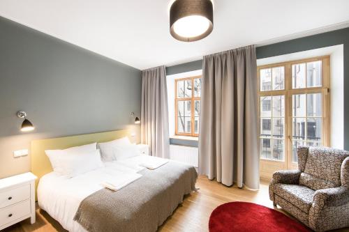 里加Riga Lux Apartments - Skolas的一间卧室配有一张床和一把椅子