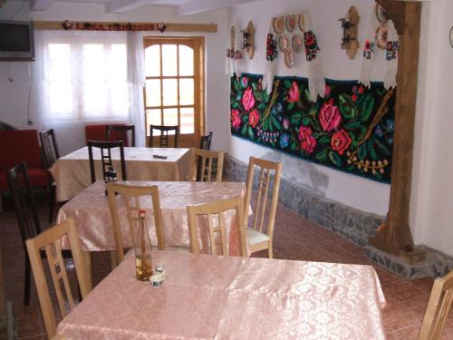 瓦杜伊泽Casa Muntean的一间设有桌子的用餐室和墙上的绘画
