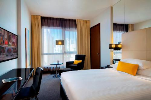 多哈多哈首府中心罗塔纳酒店的酒店客房配有一张床、一张桌子和一把椅子。