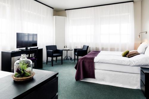 雷克雅未克22山酒店的一间卧室配有一张床和一张书桌及电视