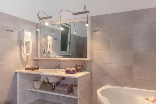 阿凡杜Belvedere Beachfront Villa的一间带水槽、浴缸和镜子的浴室