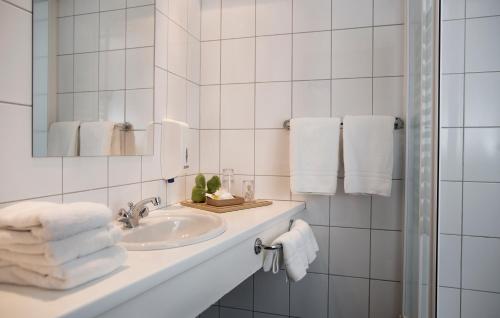 雷克雅未克22山酒店的浴室配有盥洗盆、镜子和毛巾