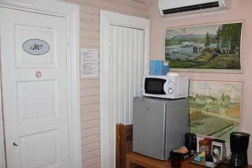 RääkkyläPaksuniemen Majatalo的厨房配有冰箱上方的微波炉