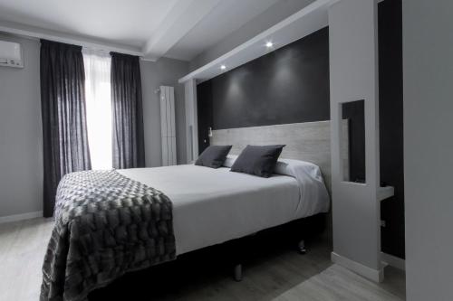 马德里马德里奥威奈特旅馆的一间卧室配有一张白色大床和黑色墙壁