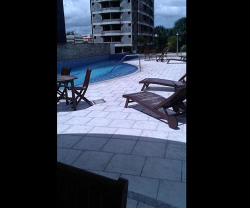 马瑙斯Ajuricaba Suites 6的一个带桌椅的庭院和一个游泳池