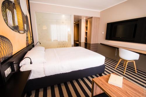 法兰西堡西蒙酒店的配有一张床和一台平面电视的酒店客房