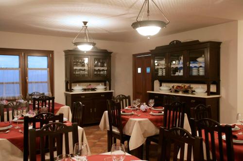 VillayónHotel Rural Yeguada Albeitar的一间带桌椅和红色桌布的用餐室