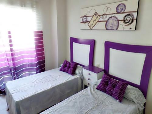 卡拉德费斯特拉特Sidney的一间卧室配有两张床和紫色枕头