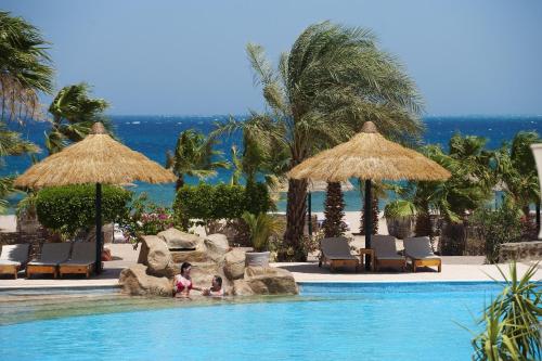 赫尔格达莲花湾度假酒店的两人在度假村的游泳池里