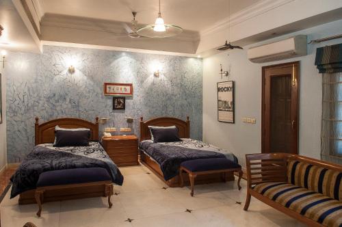 新德里33号别墅住宿加早餐旅馆的一间带两张床和一张沙发的卧室