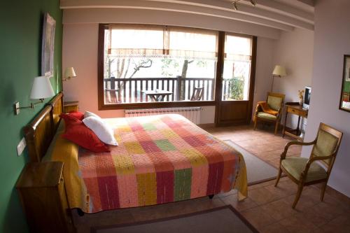 宏达瑞比亚伊赫拉尔德乡村旅馆的一间卧室配有一张带彩色毯子和窗户的床。