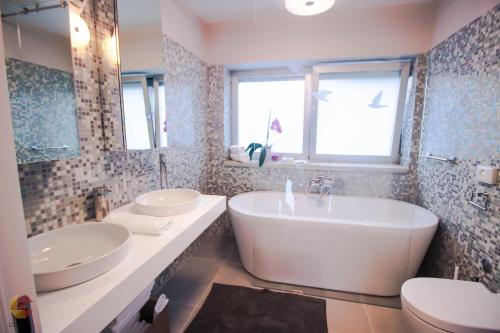 罗维尼伯尼克红土别墅酒店的一间带两个盥洗盆、浴缸和卫生间的浴室