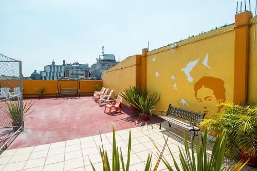 墨西哥城Hotel Amigo Suites的墙上挂着人类壁画的庭院