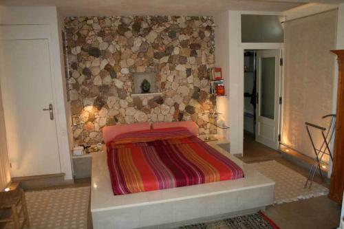 厄尔·坎皮洛·德·罗达尔Complejo La Ermita的一间卧室配有一张石墙床