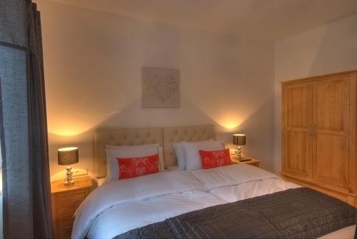 滨湖采尔滑雪和高尔夫​​所卡普伦出租小屋公寓的一间卧室配有一张带红色枕头的大床