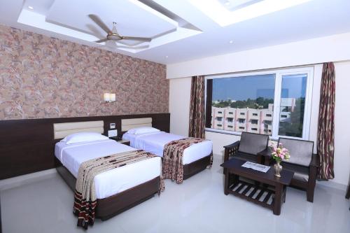 蒂鲁奇奇拉帕利Hotel Deepam的酒店客房设有两张床和窗户。