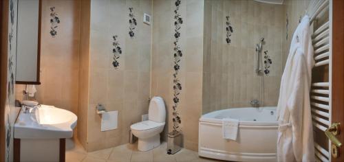 克拉约瓦Hotel Emma West的带浴缸、卫生间和盥洗盆的浴室
