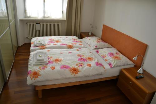 博尔扎诺Guesthouse Bauzanum Streiter的一间卧室配有两张鲜花床。