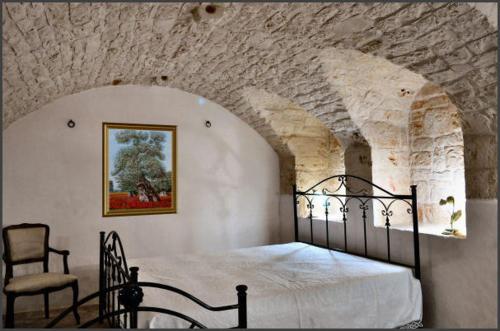 普蒂尼亚诺Masseria Costanza的卧室配有一张石墙床