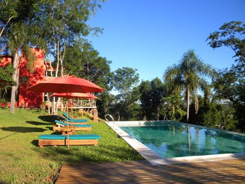 埃尔索韦维奥埃尔索韦维奥山林小屋的游泳池配有椅子、红伞和桌子
