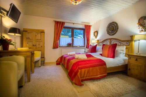 鲁波尔丁加尼泽兰卡旅馆的一间卧室配有一张床、一张书桌和一个窗户。