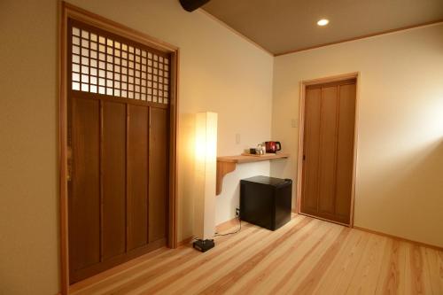 京都京都满月住宿加早餐旅馆的一间有门的房间,里面设有一台电视