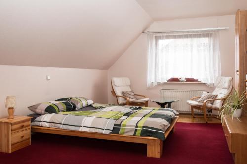 诺伊斯Privatunterkunft "An der Hecke"的一间卧室配有床、椅子和窗户