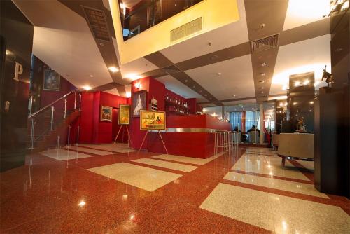 普列文普列文城市酒店的大厅,有红色的墙壁和楼梯,位于大楼内
