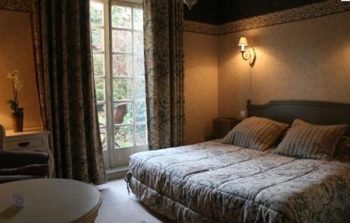 康布雷精艺轩酒店的一间卧室设有一张床和一个大窗户