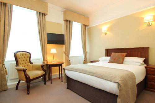 都柏林城堡酒店的配有一张床和一把椅子的酒店客房