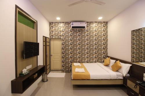 孟买黄金酒店的一间卧室配有一张床和一台电视。