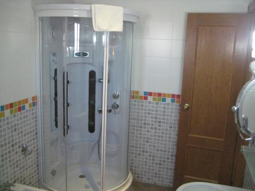 普埃托利亚诺维洛拉酒店的浴室里设有玻璃门淋浴