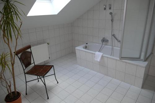 格赖夫斯瓦尔德Hotel Am Dom的一间带椅子和浴缸的浴室