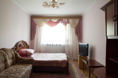 利沃夫Apartament Sanitarna 17的一间卧室配有一张床、一张沙发和一个窗口