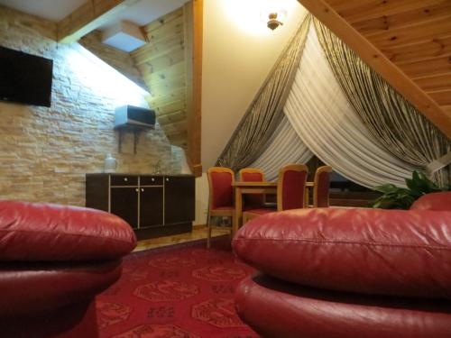 扎科帕内Residenz Polenia的客厅配有红色皮革椅子和桌子