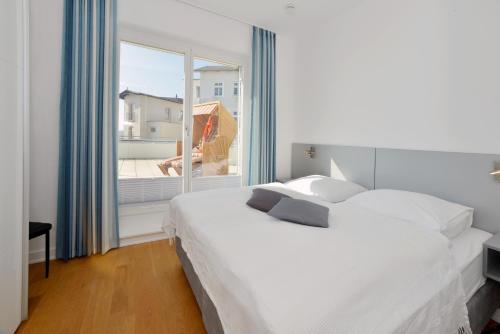 萨斯尼茨Suite Meersinn的卧室设有白色的床和大窗户