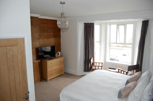 布德格罗斯夫纳宾馆的一间卧室设有一张床、一台电视和一个窗口。