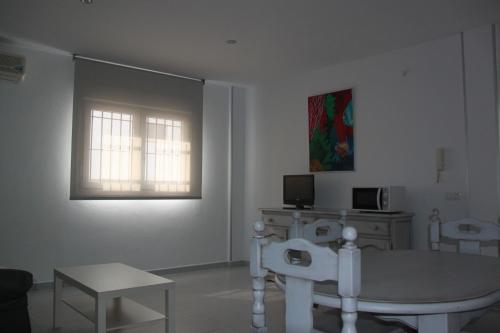 科尼尔-德拉弗龙特拉Apartamentos El Yunque- Solo Familias的客厅配有桌子和窗户