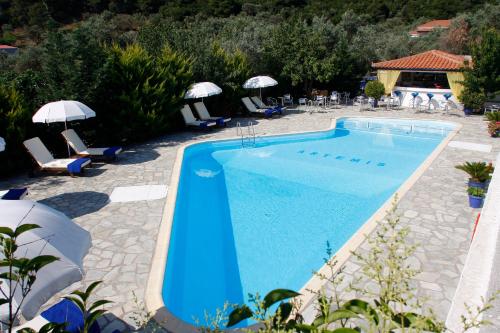 斯塔菲罗斯阿蒂米斯简易别墅的一个带椅子和遮阳伞的大型蓝色游泳池