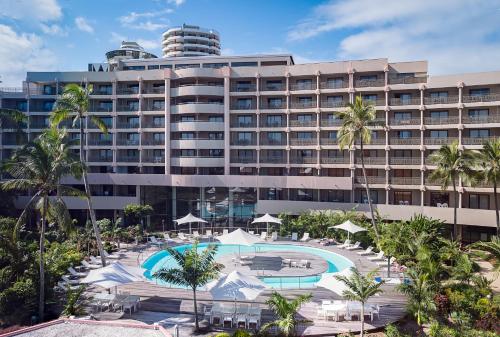 努美阿诺瓦塔酒店的一座大型酒店,设有游泳池和棕榈树