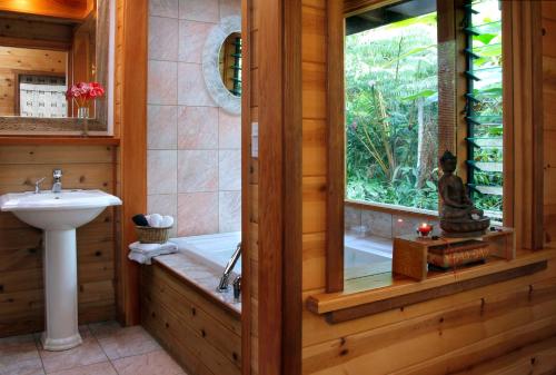 沃尔卡诺莲花园小屋旅馆的带浴缸和盥洗盆的浴室