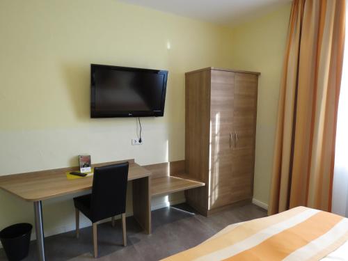 施派尔特鲁茨帕夫酒店的酒店客房设有一张桌子和一台墙上的电视