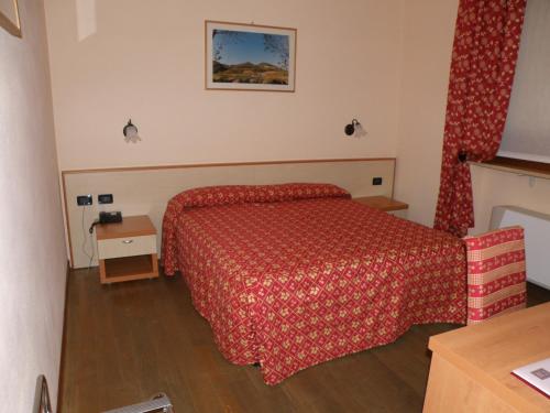 CessoleMadonna della Neve的酒店客房,配有一张红色床罩的床